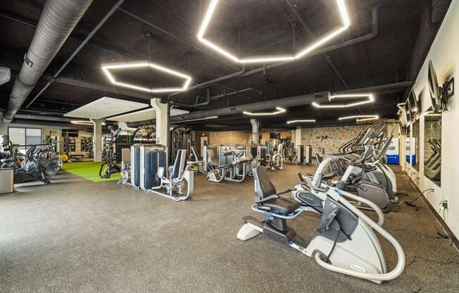 a gym with exercise equipment and lights on the ceiling at EagleRidge Plaza Residences, Fargo