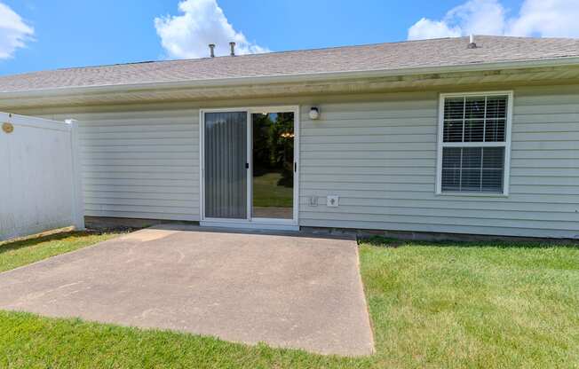 the front of a white house with a concrete driveway