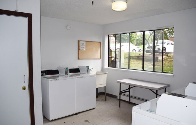 laundry room with a sink and a large window at Seville Apartments, Michigan