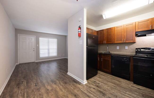 A kitchen with black appliances and wooden cabinets.