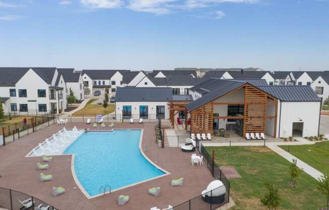 an aerial view of a swimming pool with an apartment building in the background