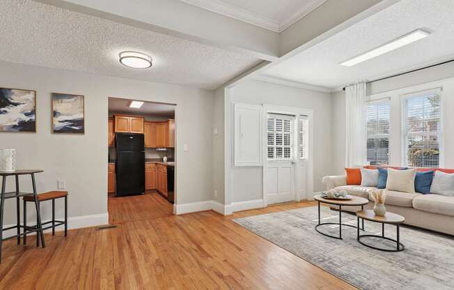 A living room with a couch, a table, and a painting on the wall.