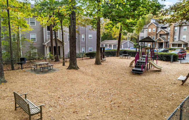 a playground with a slide and benches in a park