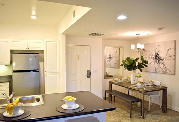 A modern kitchen with a dining table set for two.