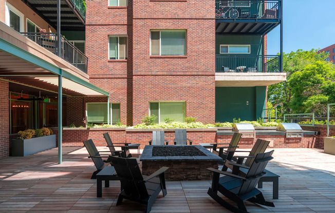 Red brick outdoor patio with chairs surrounding a fire pit at Sylvan Uptown, Colorado, 80203