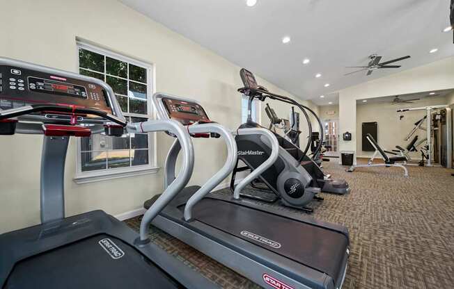 A treadmill and a stationary bike are in a home gym.