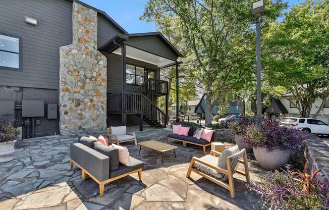 A patio with a stone pillar and furniture.