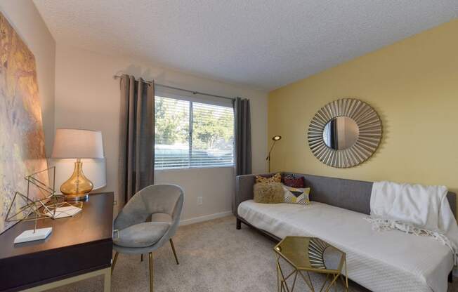 Bedroom with Large Window, White Dresser, and Gray Chair