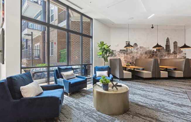 a large living room with blue couches and chairs and a large window