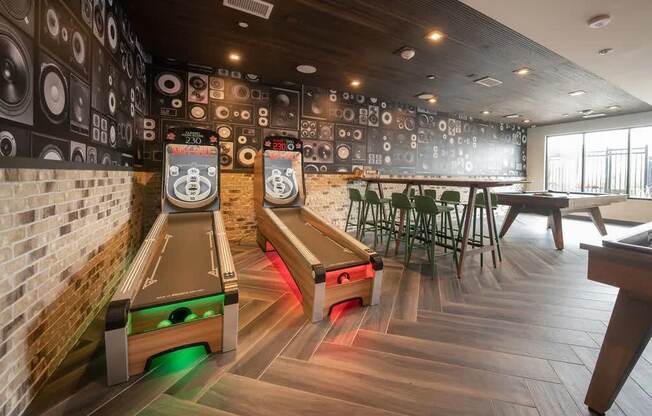 a game room with tables and chairs and a wall covered in logos