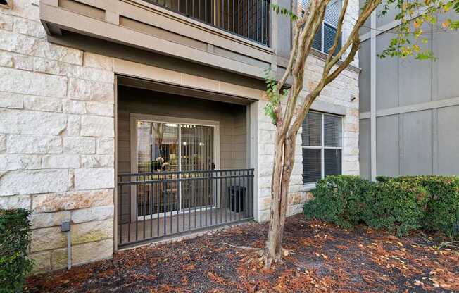 A tree is in front of a building entrance.