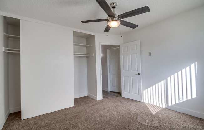 a bedroom with a ceiling fan and walk in closet