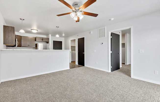 A room with a ceiling fan and carpeted floor.