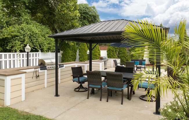 A patio with a table and chairs under a roof.