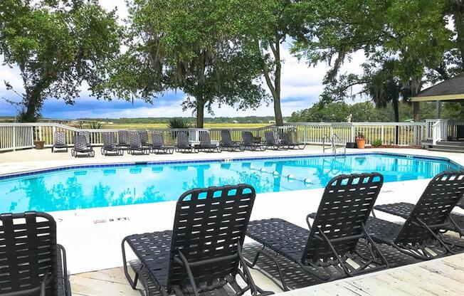 Swimming pool with black chairs at West Wind Landing, Savannah, Georgia.