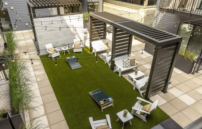 a rooftop patio with tables and chairs and a lawn