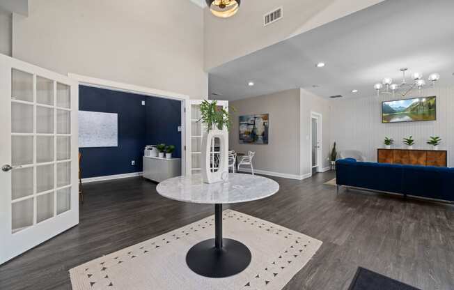 a living room with a round table and a blue couch