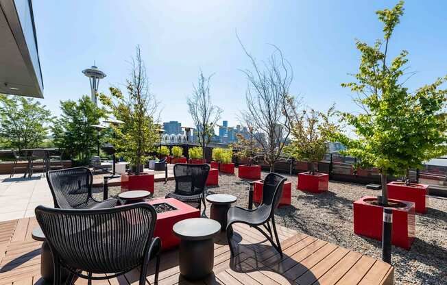 a rooftop patio with tables and chairs and trees