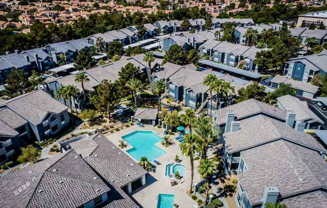 A bird's eye view of a residential area with houses and a swimming pool.