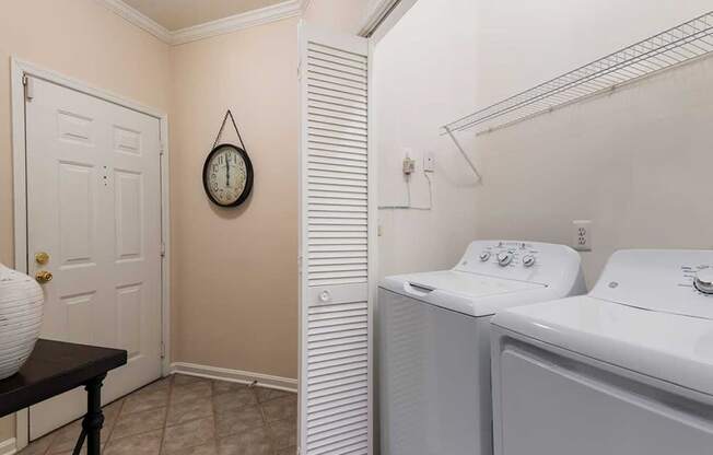 a laundry room with a washer and dryer and a door to a closet