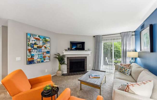 A living room with a fireplace, a painting on the wall, and a television.