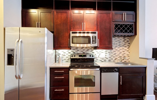 Kitchen with cherry oak cabinetry and stainless steel appliances at St. Mary's Square apartments, Raleigh, North Carolina