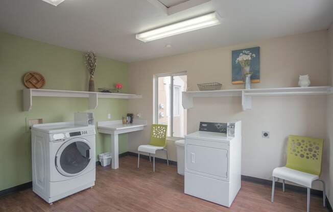 a laundry room with two washing machines and a table with chairs