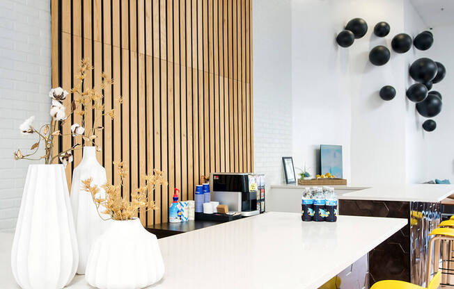 a long white counter with yellow bar stools and yellow chairs at Presidio Palms Apartments, Arizona