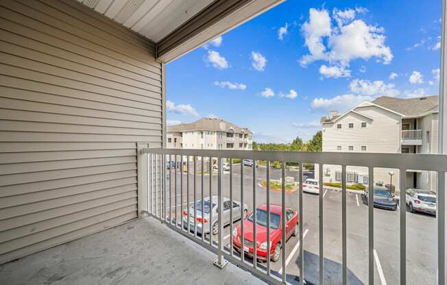 the view of a parking lot from the balcony of a house