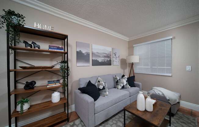 Living room in model unit with Saltillo tile floors, crown molding, and custom window binds at the Atrium Apartments in San Diego, California.