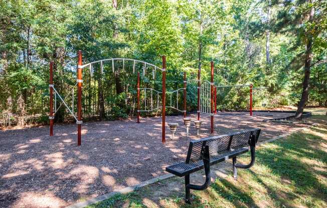 a playground with a swing set and a bench