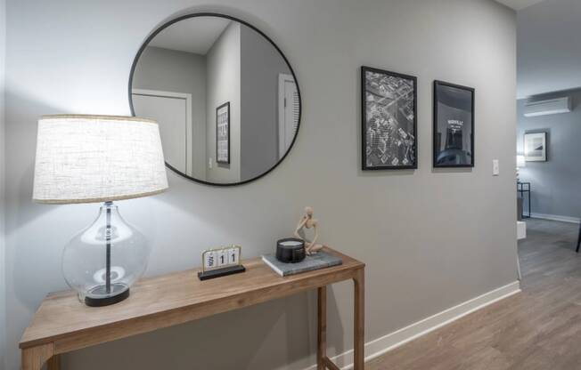 a mirror and a lamp on a table in a living room