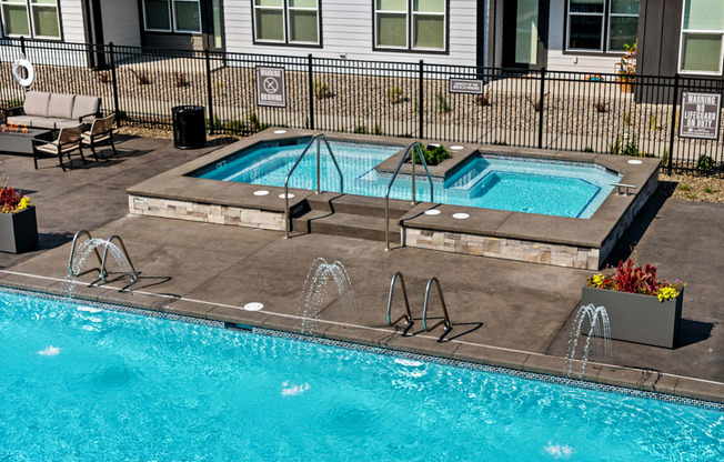 a swimming pool and spa in front of a house