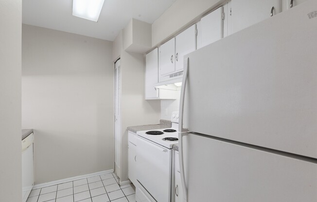 Elevate your lifestyle at Wymore 360 Apartments. This modern kitchen features sleek white cabinetry and plenty of space for culinary creativity. Enjoy convenience and comfort in every corner. Schedule your tour today!