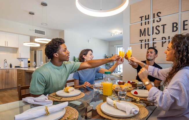 A group of people toasting with drinks at a dinner table.at Icon One, Daytona Beach, Florida