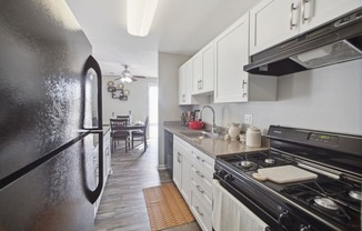 a kitchen with white cabinets and black appliances