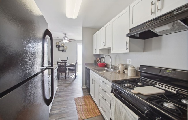 a kitchen with white cabinets and black appliances