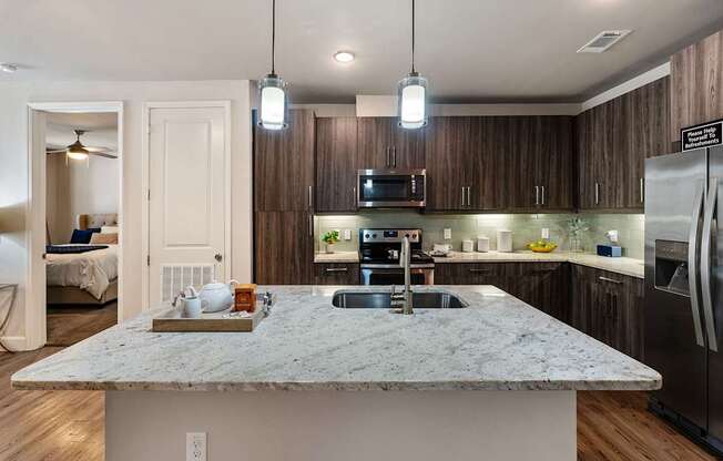 A kitchen with a marble countertop and stainless steel appliances.