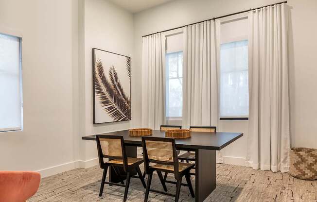 A room with a black table and chairs at the clubhouse l at Floresta apartments in Jupiter, FL