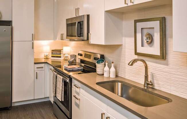 A modern kitchen with a stainless steel refrigerator and a microwave above the stove.