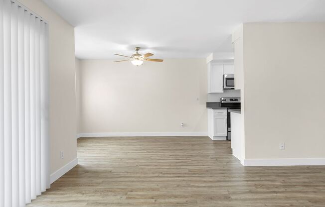A room with a ceiling fan and a microwave.