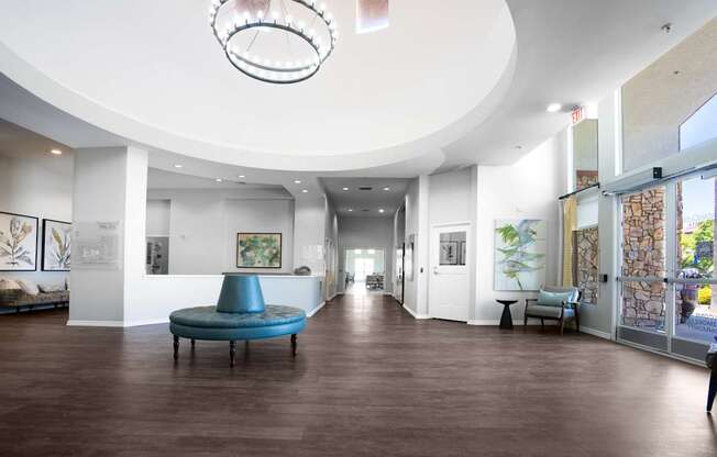 A large room with a blue ottoman in the middle of the room.
