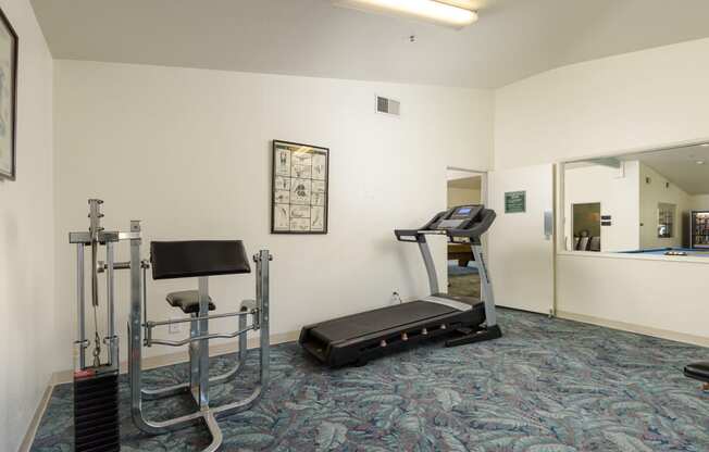 a gym with a treadmill and exercise equipment in a room