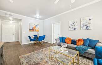 a living room with blue couches and a glass coffee table