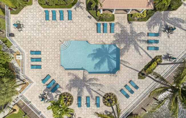 an overhead view of a swimming pool with umbrellas and chairs