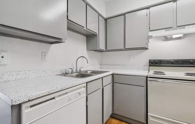 A kitchen with white appliances and cabinets.