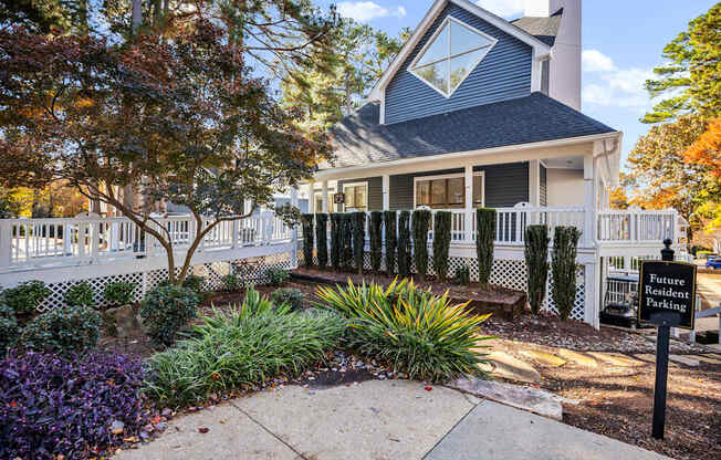 A house with a white picket fence and a sign that says Future Student Parking.