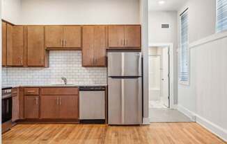 a kitchen with wooden cabinets and a stainless steel refrigerator