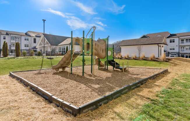 Ashland Farms Outdoor Playground on Tanbark Surrounded by Lush Greenery