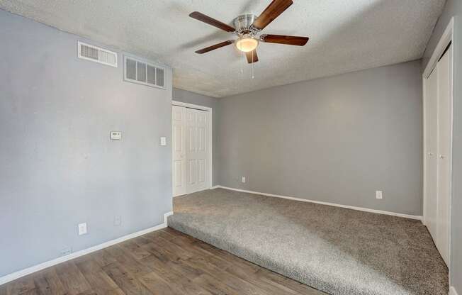 the spacious living room has a ceiling fan and a carpet